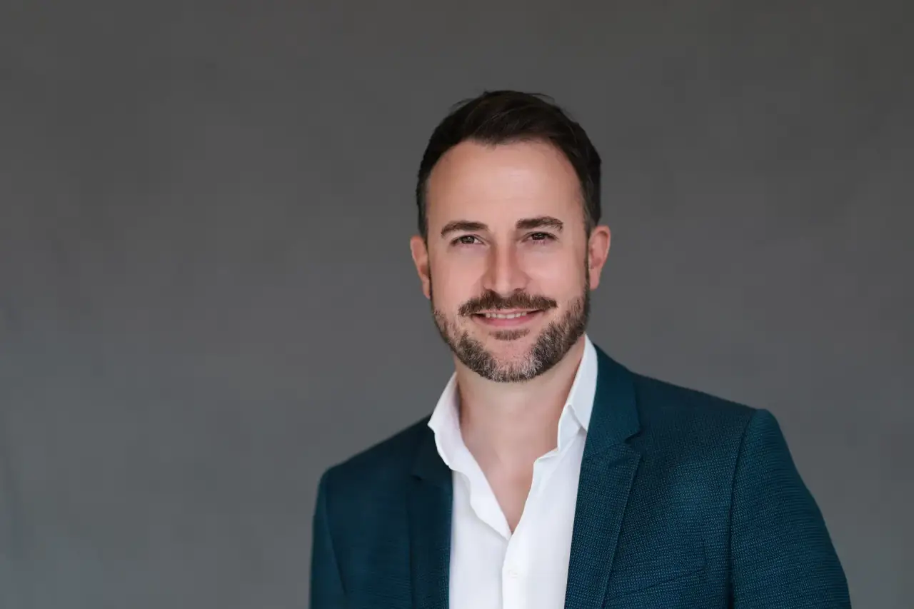 Klassisches Bewerbungsfoto eines Mannes mit blauem Blazer vor grauem Hintergrund – professionelles Studio Hamburg