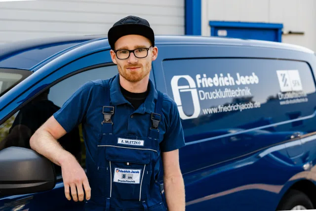 Mitarbeiterporträt Serviceleiter mit verschränkten Armen vor Transporter