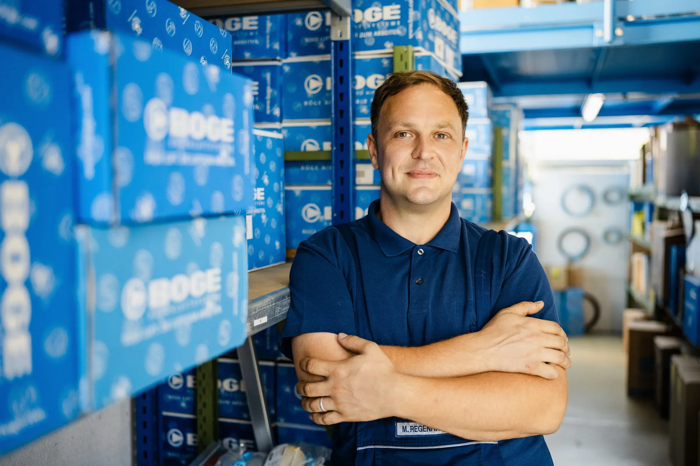Mitarbeiterfotos Hamburg – Handwerker im Lager blickt in die Kamera, Portrait am Arbeitsplatz